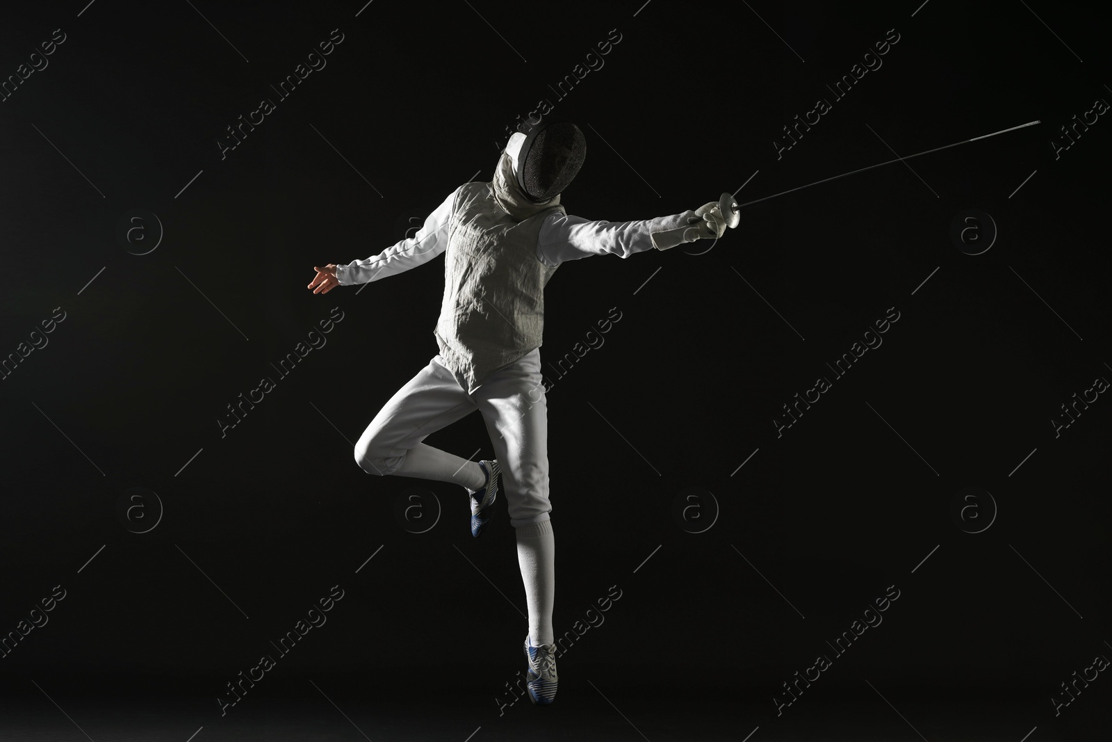 Photo of Fencer with epee practicing on black background