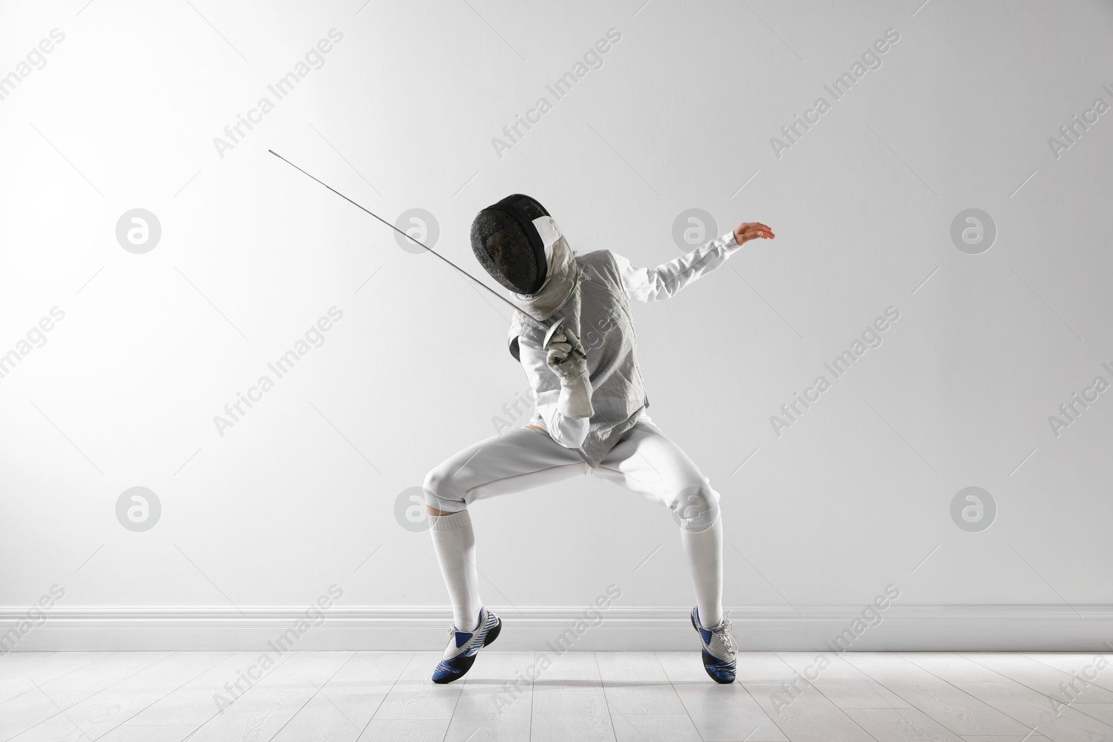 Photo of Fencer with epee practicing indoors. Combat sport