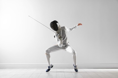 Photo of Fencer with epee practicing indoors. Combat sport