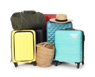 Photo of Many colorful suitcases, beach bag and straw hat isolated on white