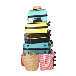 Photo of Stack of colorful suitcases, beach bags and straw hat isolated on white