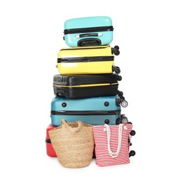 Photo of Stack of colorful suitcases and beach bags isolated on white