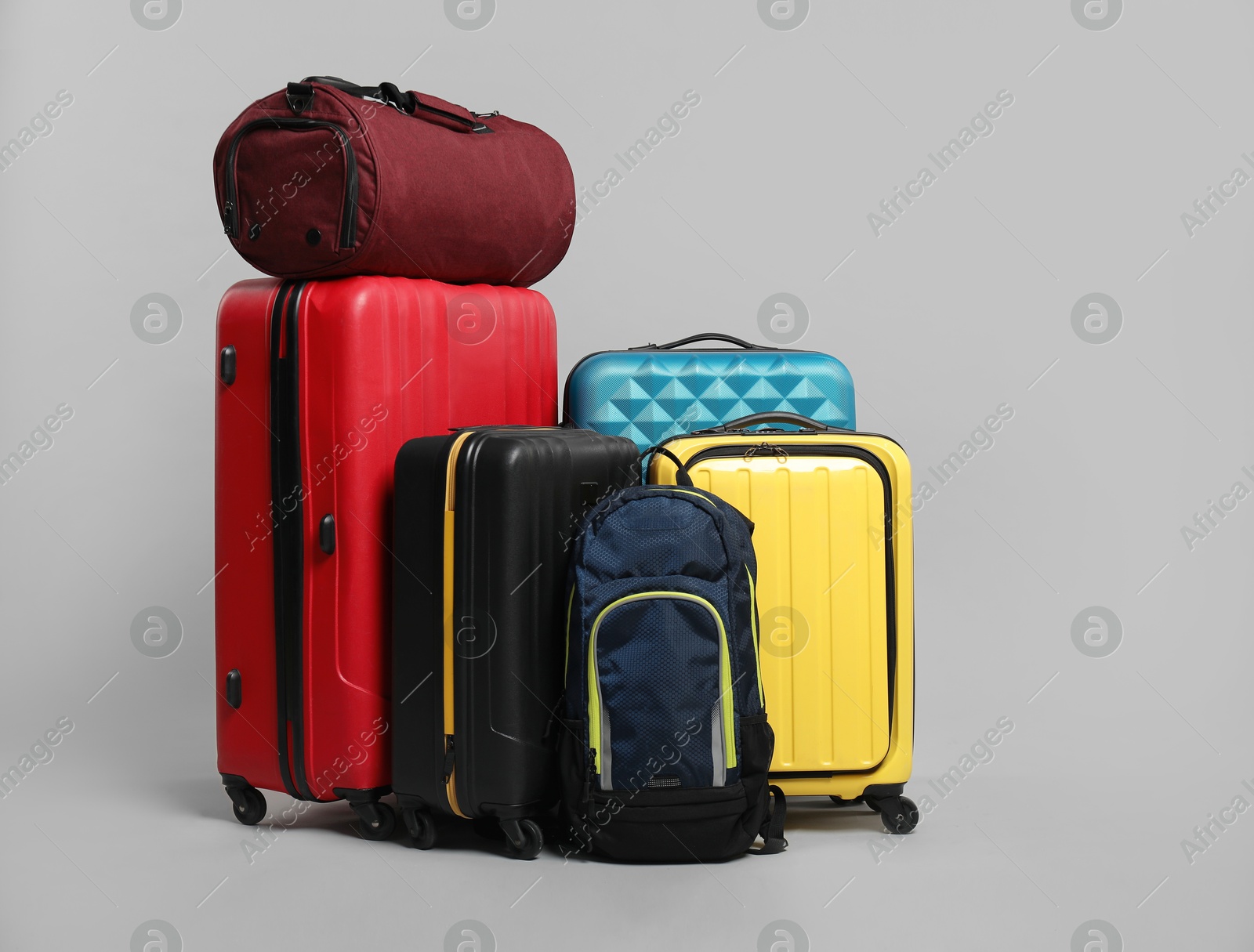 Photo of Many colorful suitcases, backpack and bag on grey background