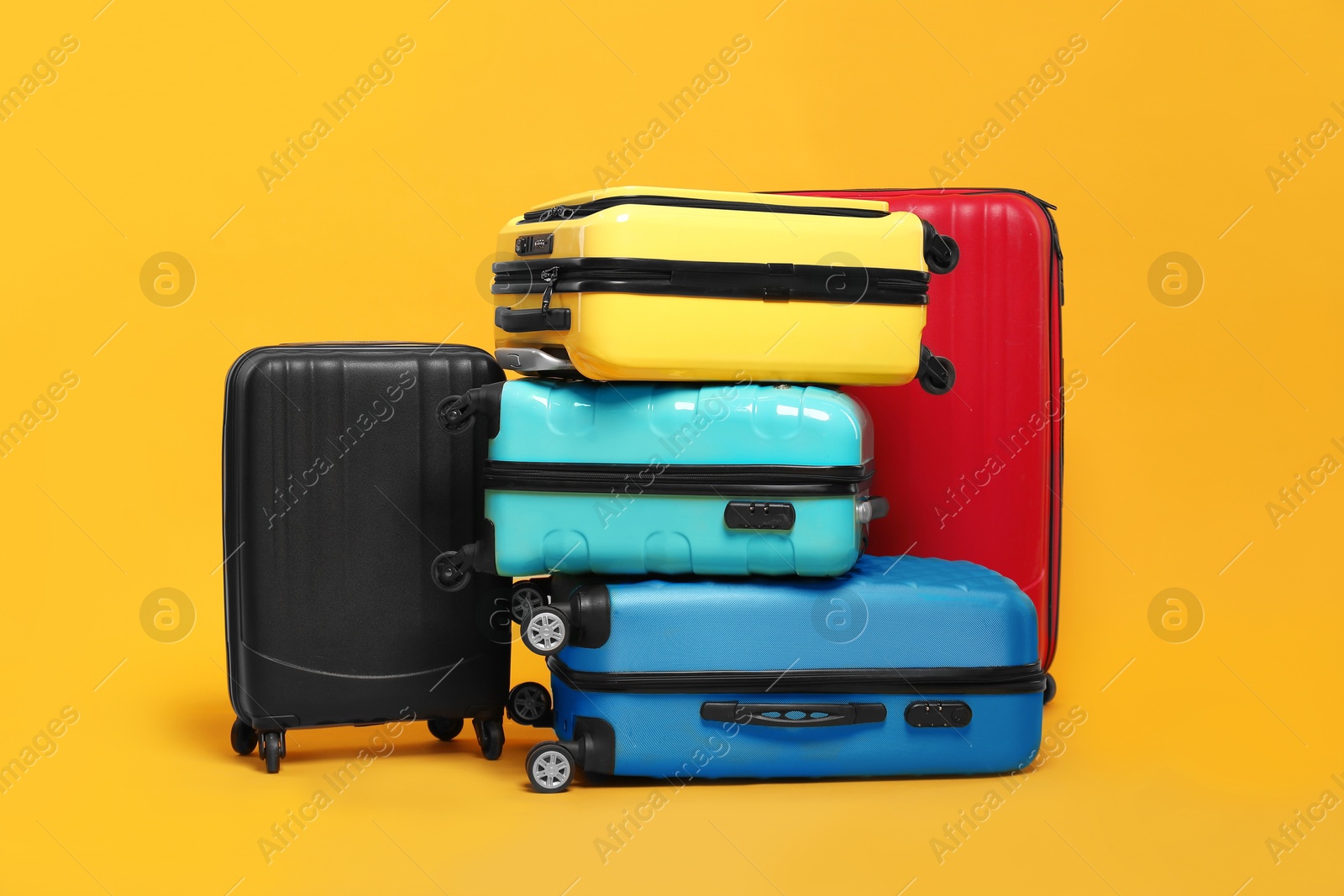 Photo of Many closed colorful suitcases on orange background