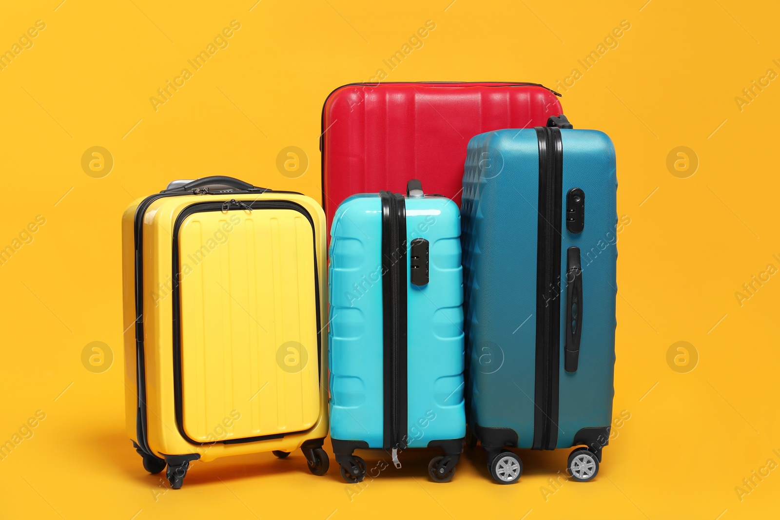 Photo of Many closed colorful suitcases on orange background