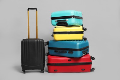 Photo of Many closed colorful suitcases on grey background