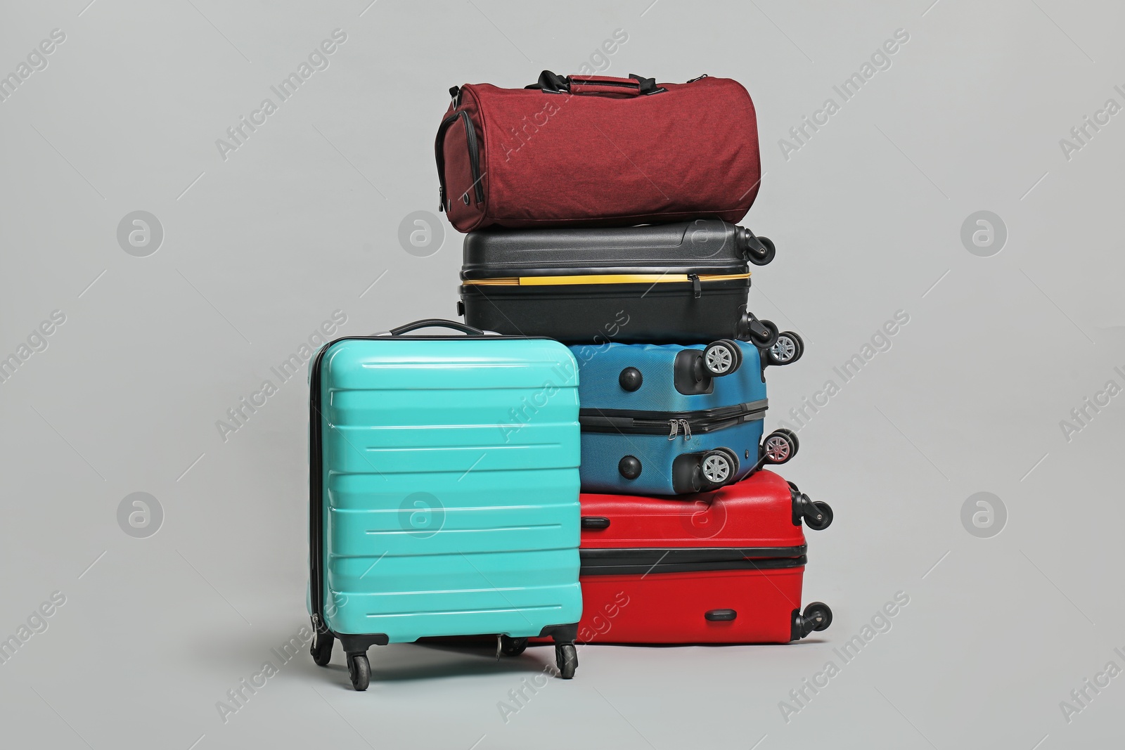 Photo of Many colorful suitcases and bag on grey background