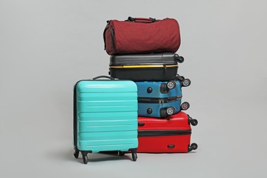 Photo of Many colorful suitcases and bag on grey background