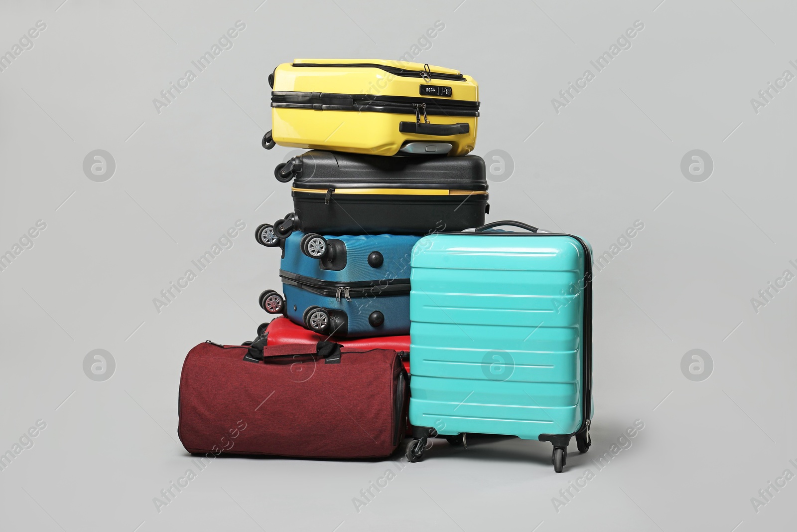 Photo of Many colorful suitcases and bag on grey background