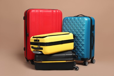 Photo of Many closed colorful suitcases on beige background