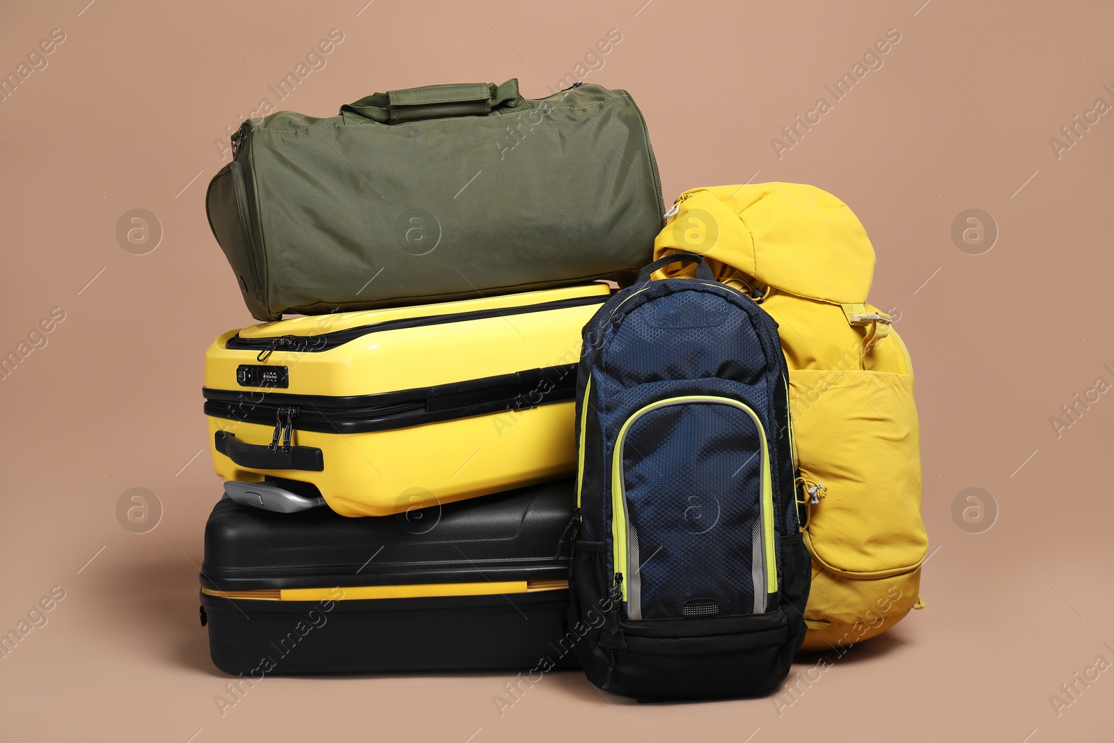 Photo of Colorful suitcases, backpacks and bag on beige background