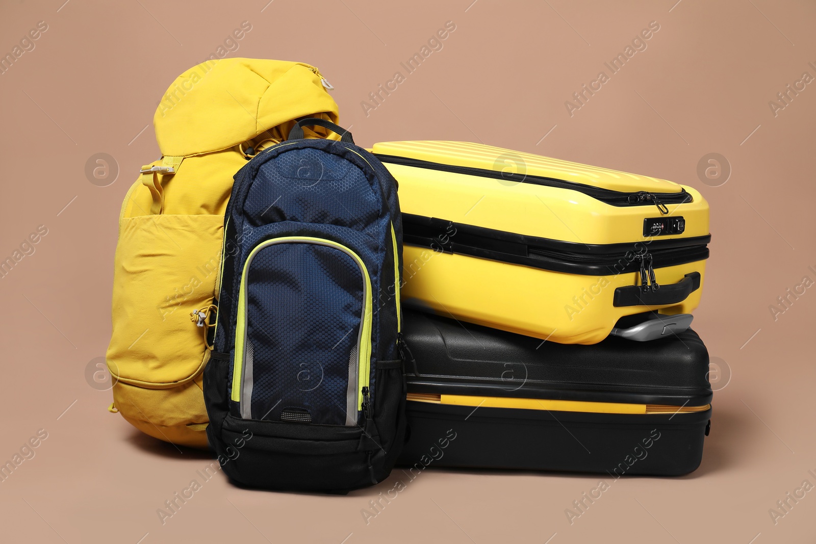 Photo of Colorful suitcases and backpacks on beige background