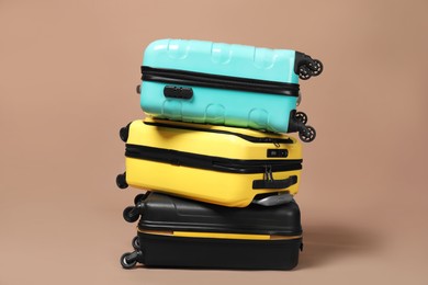 Photo of Stack of colorful suitcases on beige background