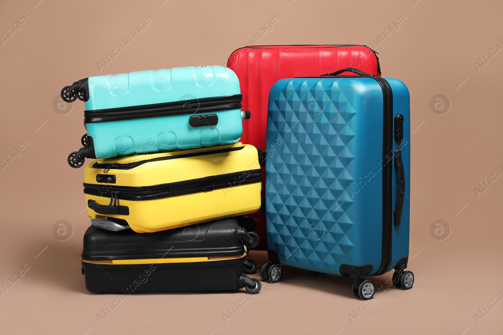 Photo of Many closed colorful suitcases on beige background