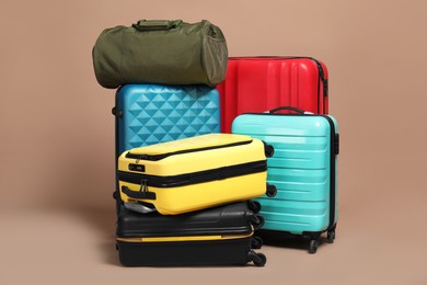 Photo of Many colorful suitcases and bag on beige background