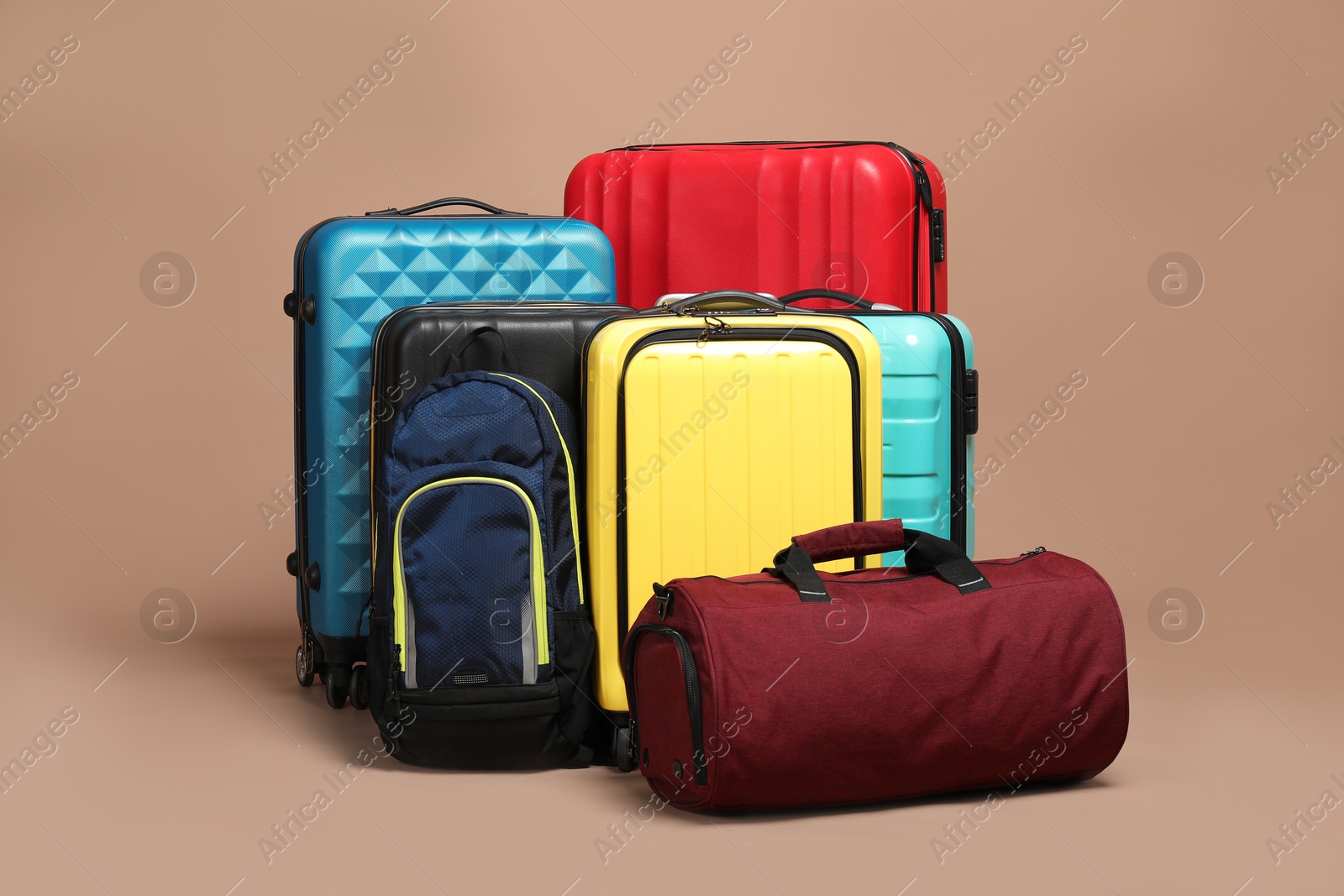 Photo of Many colorful suitcases, backpack and bag on beige background