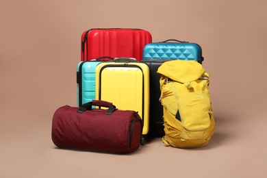 Photo of Many colorful suitcases, backpack and bag on beige background