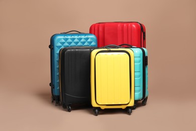 Photo of Many closed colorful suitcases on beige background