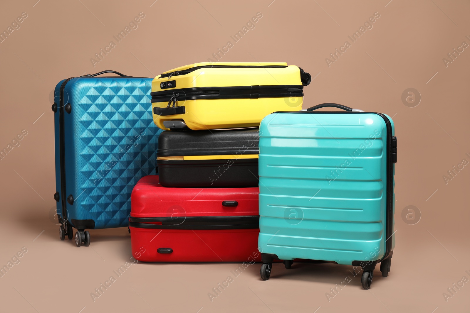 Photo of Many closed colorful suitcases on beige background