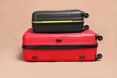 Two closed colorful suitcases on beige background