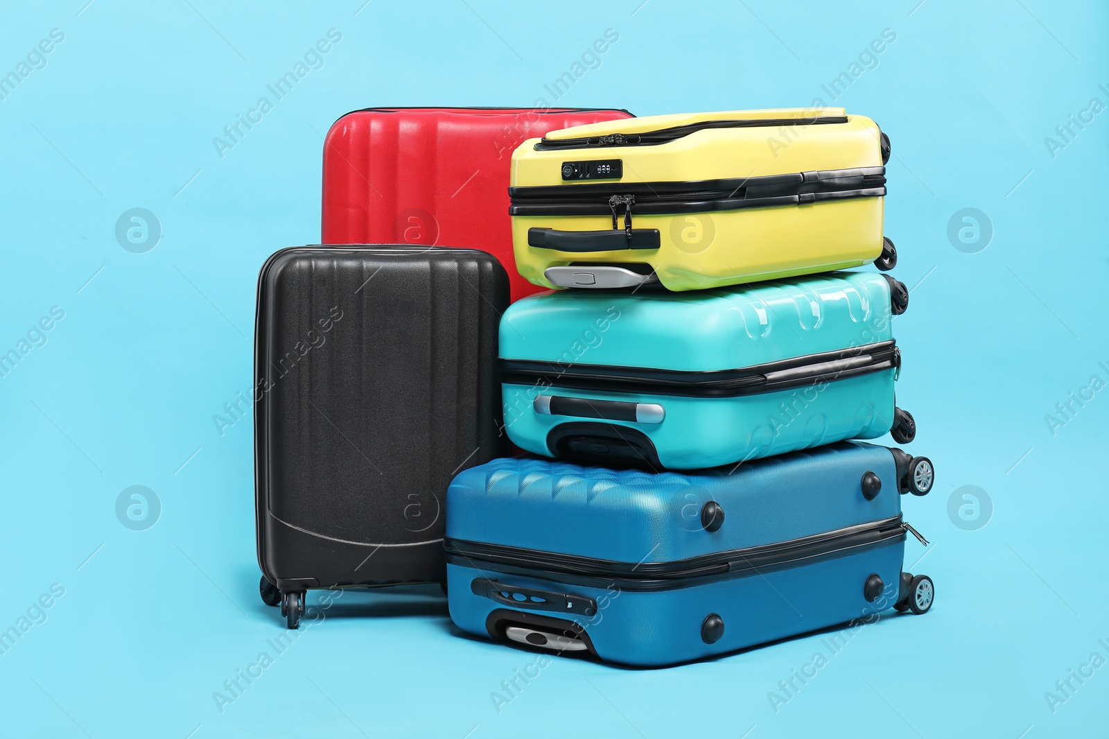 Photo of Many colorful suitcases on light blue background