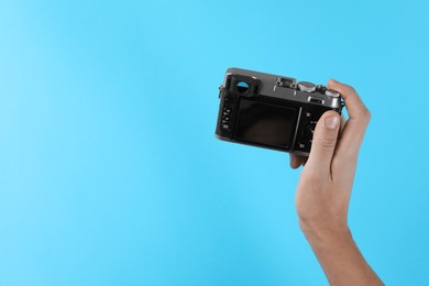 Photo of Photographer with vintage camera on light blue background, space for text