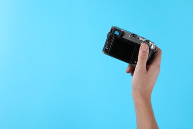 Photo of Photographer with vintage camera on light blue background, space for text