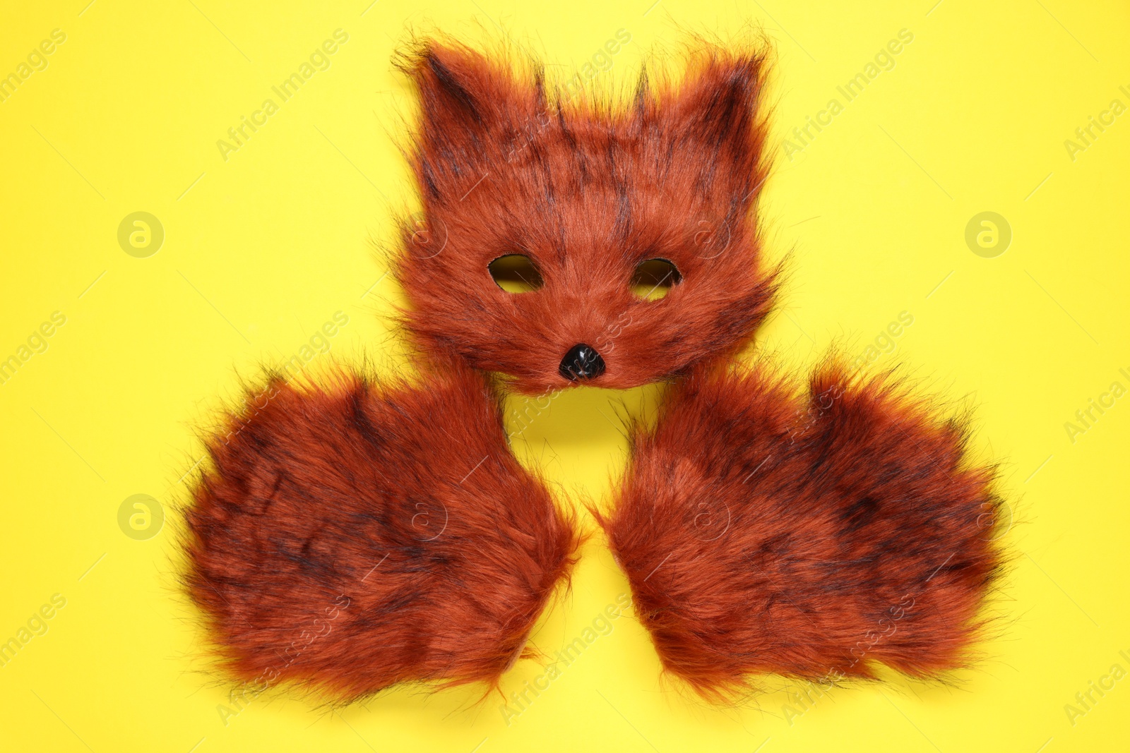 Photo of Quadrobics. Fox mask and gloves on yellow background, top view