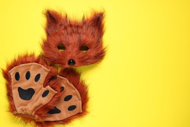 Photo of Quadrobics. Fox mask and gloves on yellow background, top view. Space for text