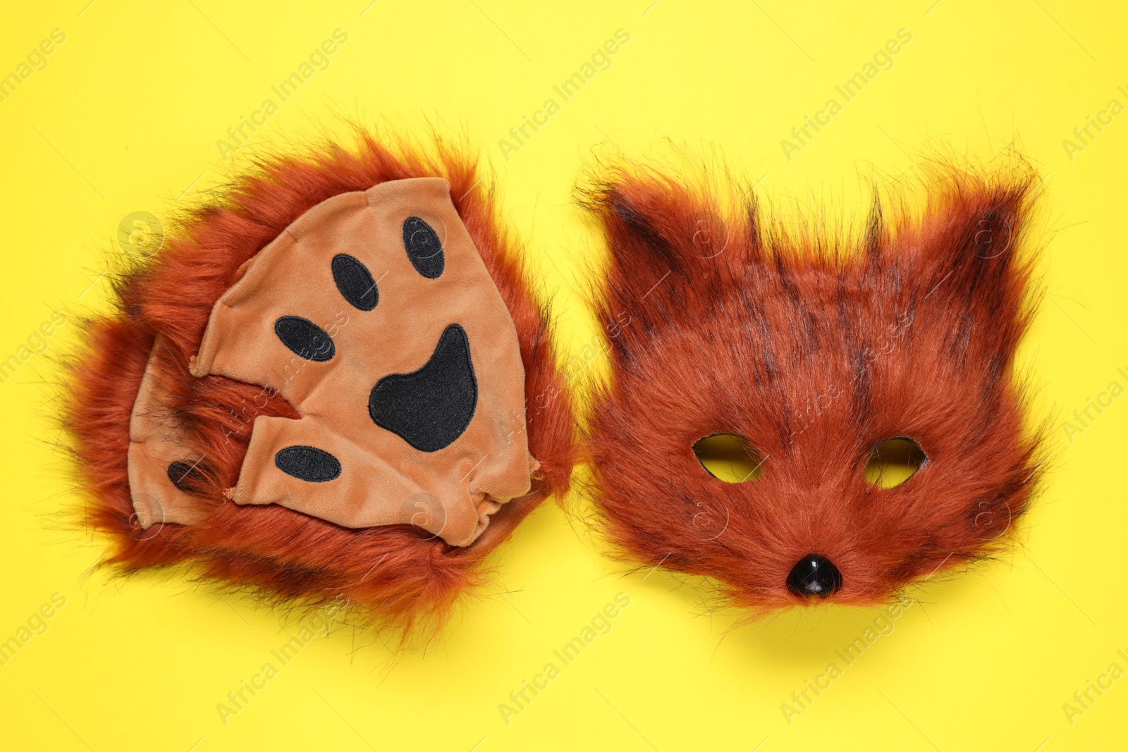 Photo of Quadrobics. Fox mask and gloves on yellow background, top view