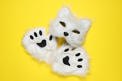 Photo of Quadrobics. Cat mask and gloves on yellow background, top view