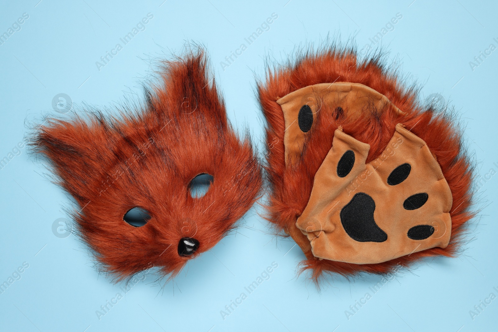 Photo of Quadrobics. Fox mask and gloves on light blue background, top view