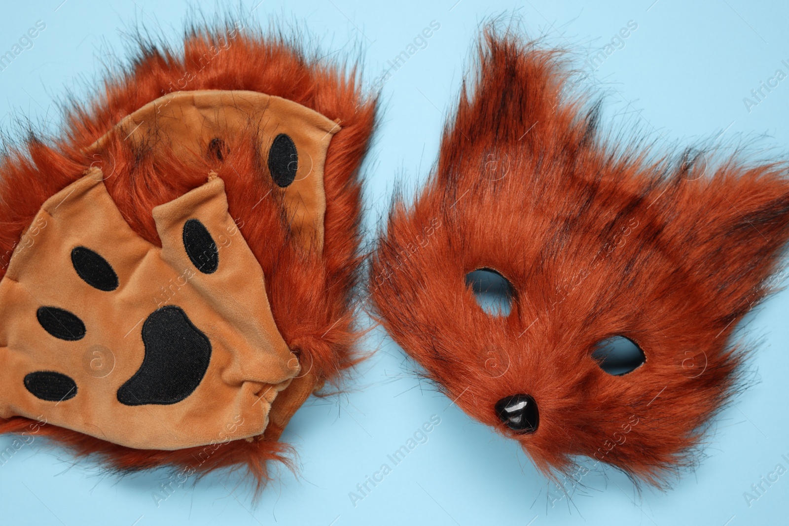 Photo of Quadrobics. Fox mask and gloves on light blue background, top view