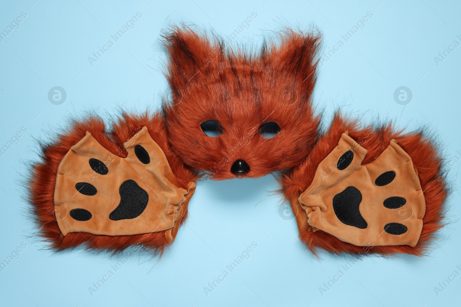 Photo of Quadrobics. Fox mask and gloves on light blue background, top view