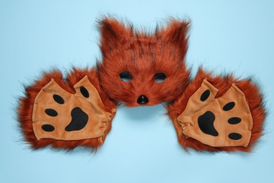 Photo of Quadrobics. Fox mask and gloves on light blue background, top view