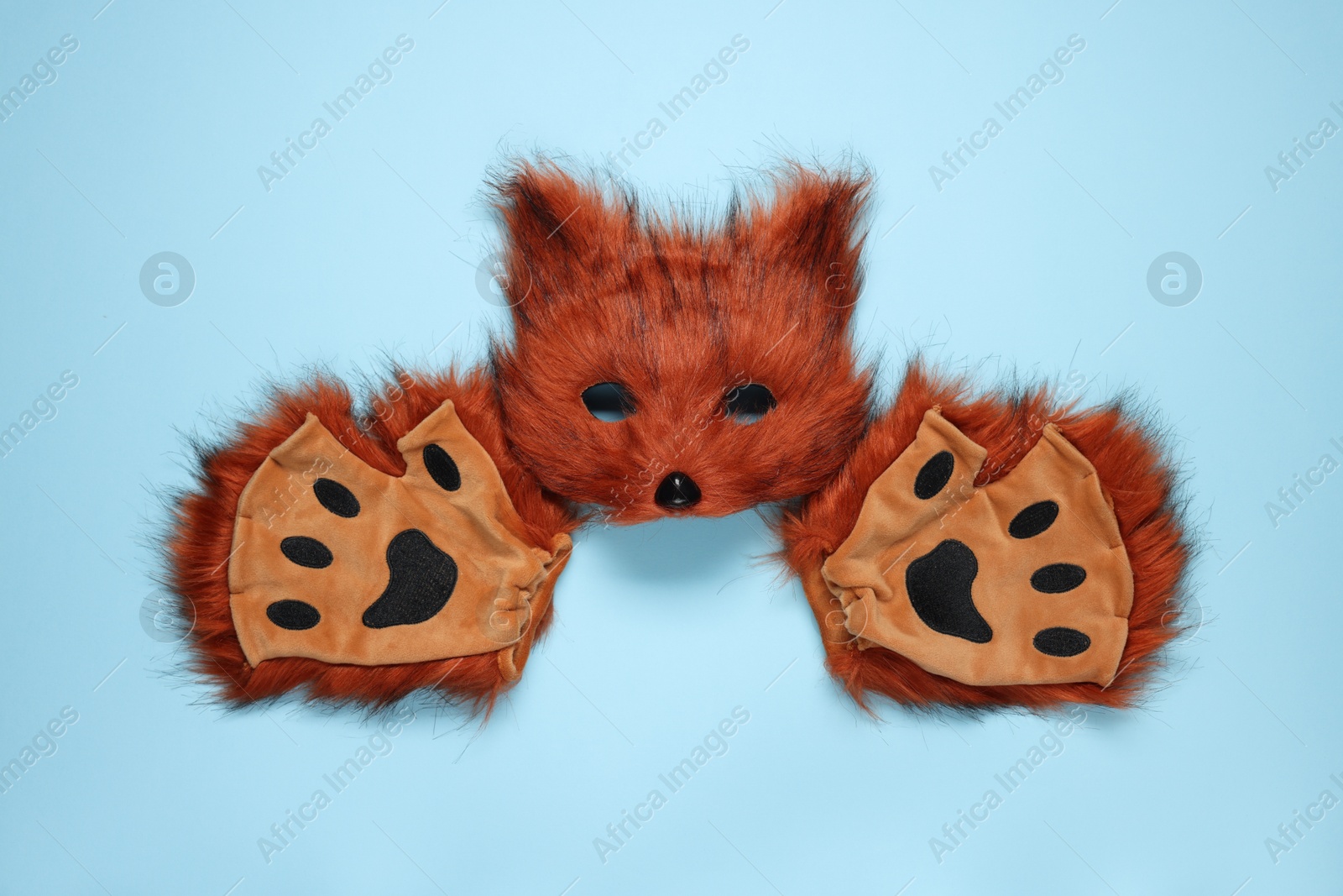 Photo of Quadrobics. Fox mask and gloves on light blue background, top view