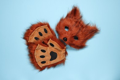 Photo of Quadrobics. Fox mask and gloves on light blue background, top view