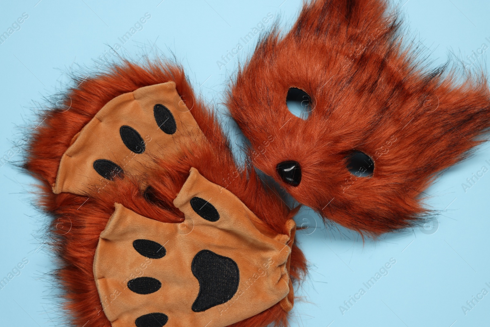 Photo of Quadrobics. Fox mask and gloves on light blue background, top view