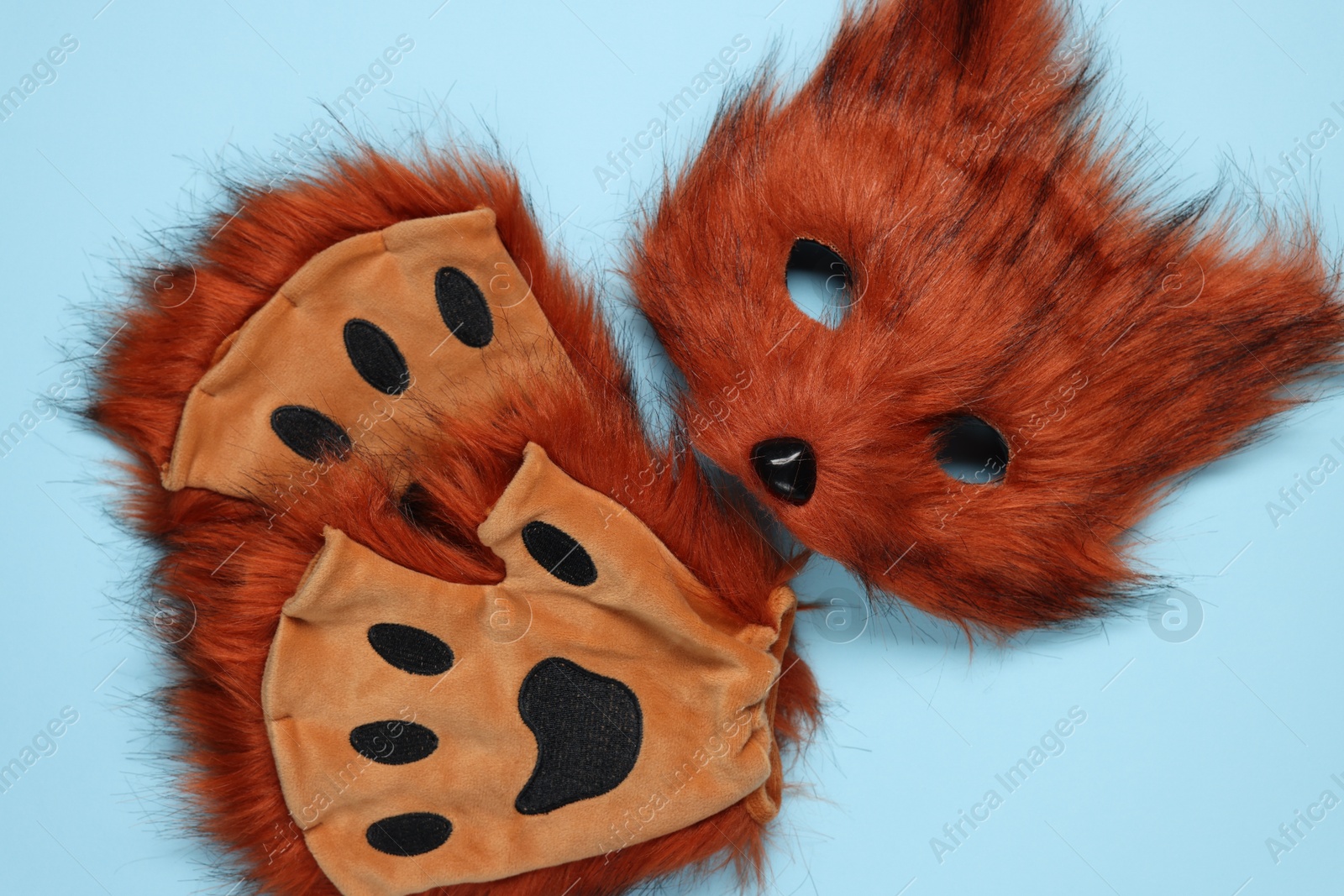 Photo of Quadrobics. Fox mask and gloves on light blue background, top view