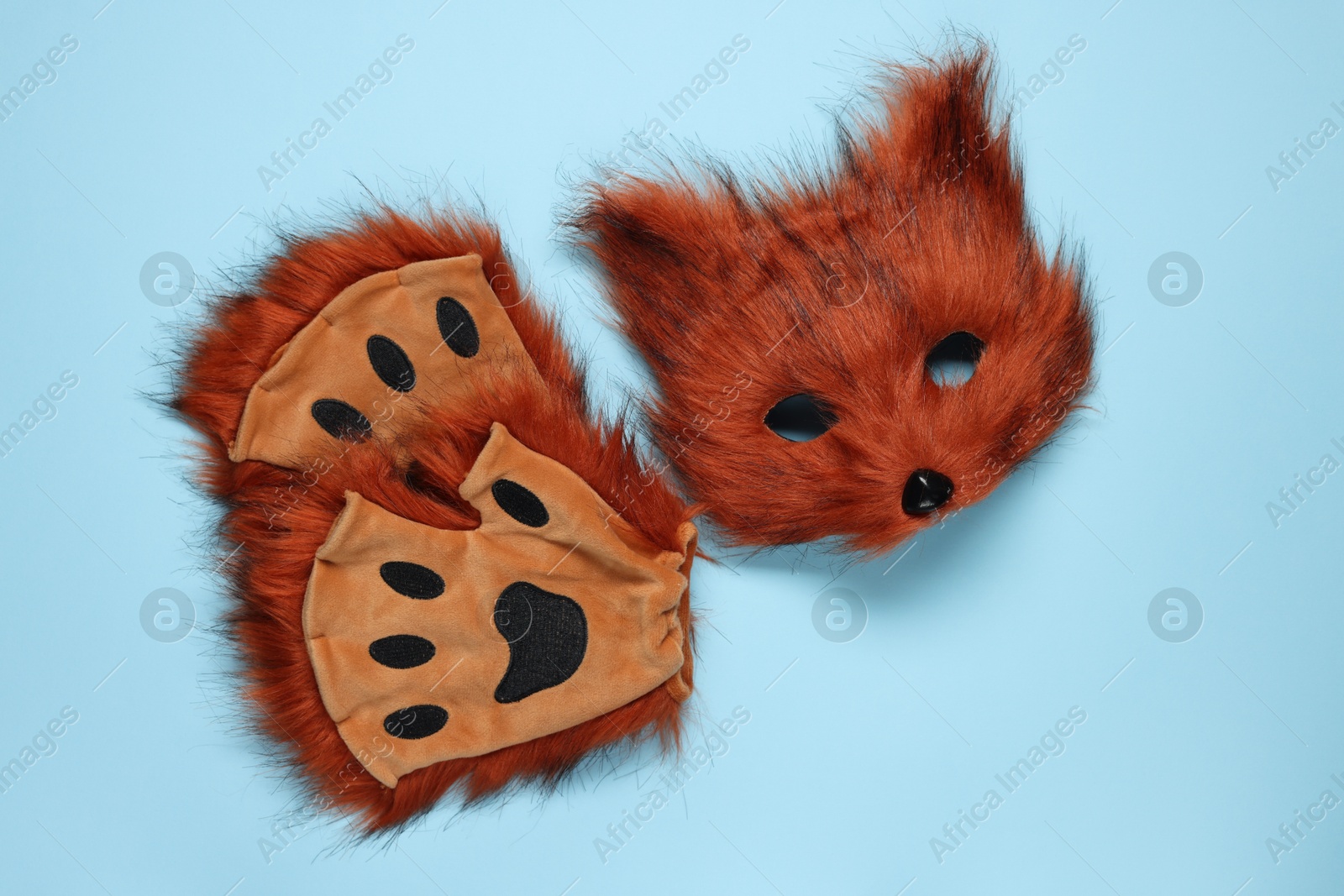 Photo of Quadrobics. Fox mask and gloves on light blue background, top view