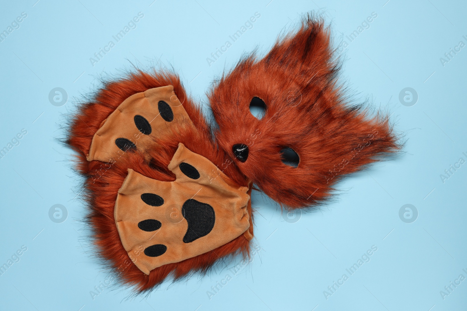 Photo of Quadrobics. Fox mask and gloves on light blue background, top view