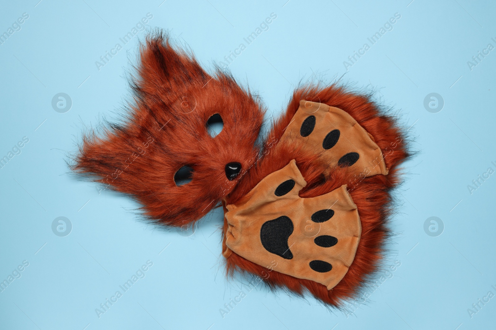 Photo of Quadrobics. Fox mask and gloves on light blue background, top view