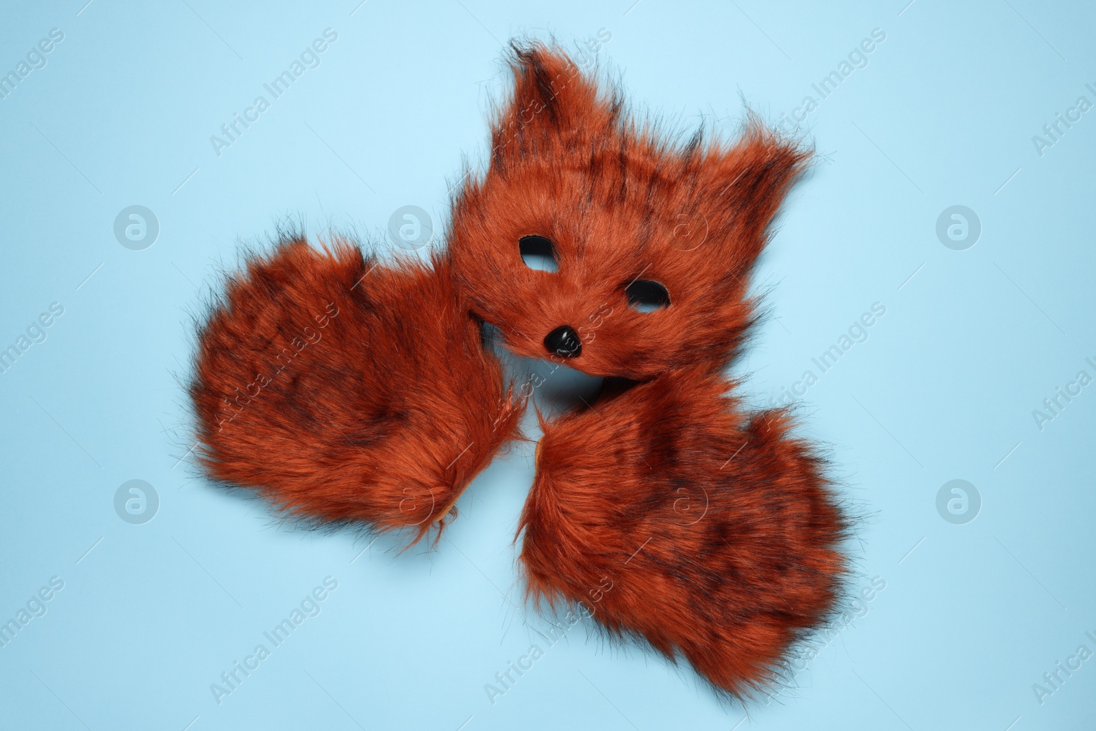 Photo of Quadrobics. Fox mask and gloves on light blue background, top view