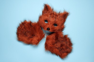 Photo of Quadrobics. Fox mask and gloves on light blue background, top view