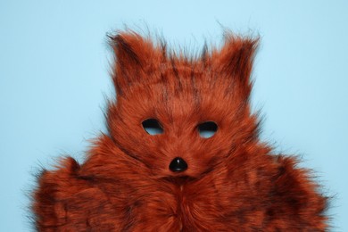 Photo of Quadrobics. Fox mask and gloves on light blue background, top view