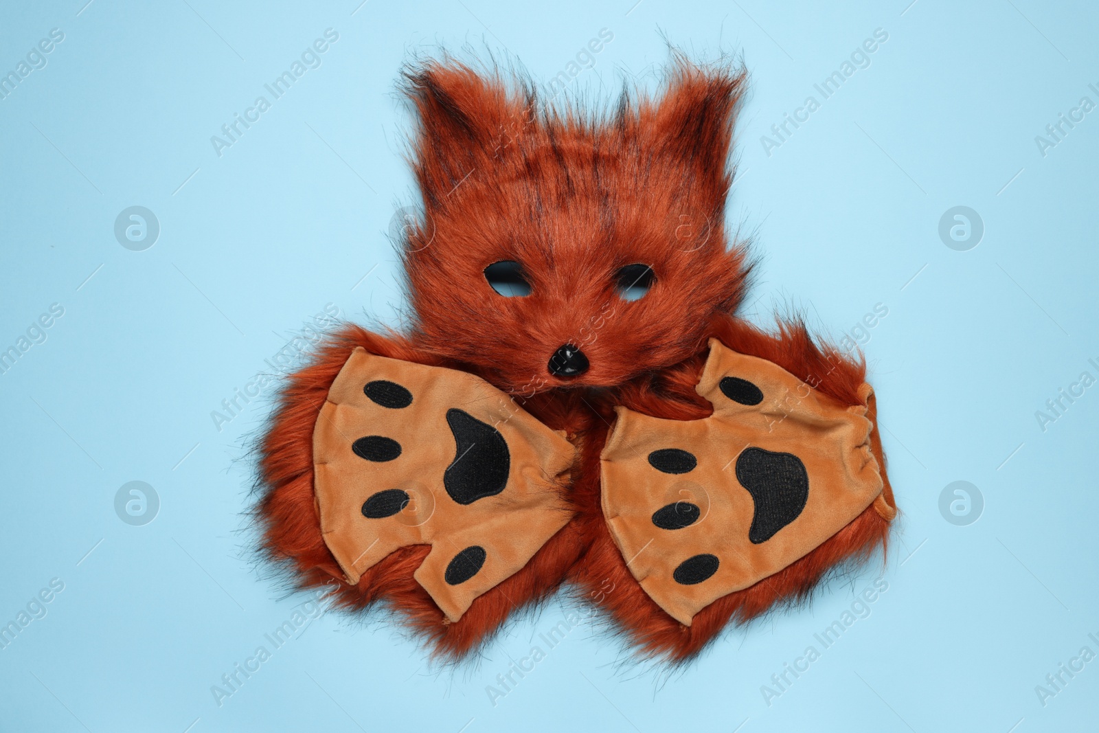 Photo of Quadrobics. Fox mask and gloves on light blue background, top view