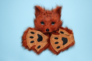 Photo of Quadrobics. Fox mask and gloves on light blue background, top view