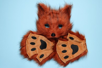 Photo of Quadrobics. Fox mask and gloves on light blue background, top view