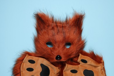 Photo of Quadrobics. Fox mask and gloves on light blue background, top view