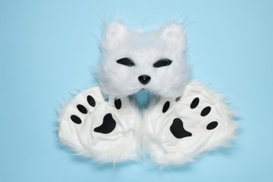 Photo of Quadrobics. Cat mask and gloves on light blue background, top view